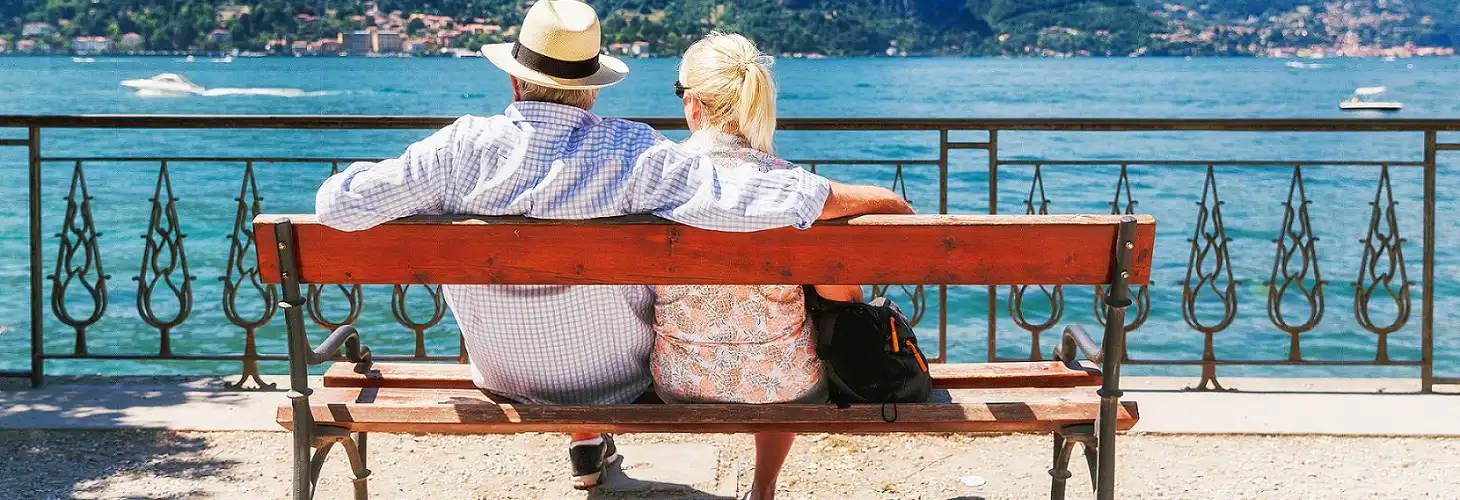 Ehepaar entspannt auf Bank vor See